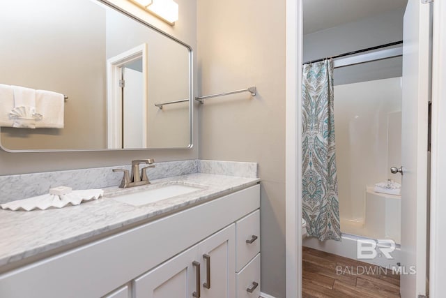 bathroom with wood finished floors, vanity, and shower / bath combo