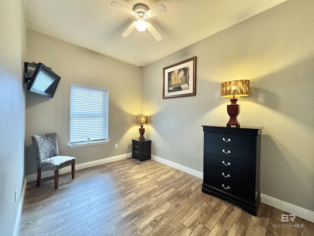 sitting room featuring wood finished floors, ceiling fan, and baseboards
