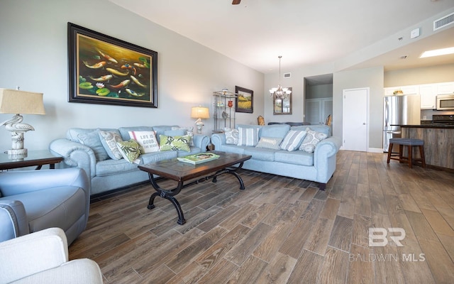 living room with dark wood-style floors and a chandelier