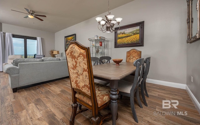 dining room with baseboards, a chandelier, wood finished floors, and a ceiling fan