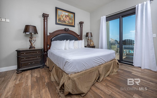bedroom with access to exterior, wood finished floors, and baseboards