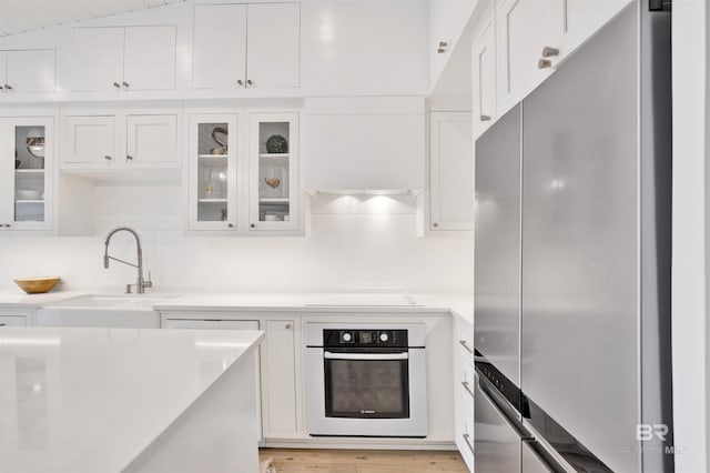 210 S Mobile St Unit 16, Fairhope, AL 36532 - kitchen featuring appliances with stainless steel finishes, white cabinets, light countertops, and a sink