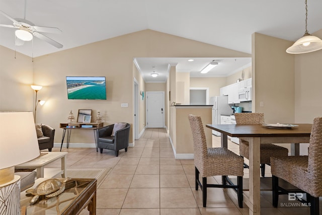 tiled dining space featuring ceiling fan, ornamental molding, and vaulted ceiling