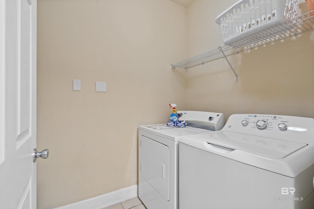 clothes washing area featuring washer and clothes dryer and light tile patterned flooring