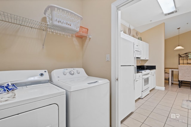 laundry area with light tile patterned floors and independent washer and dryer