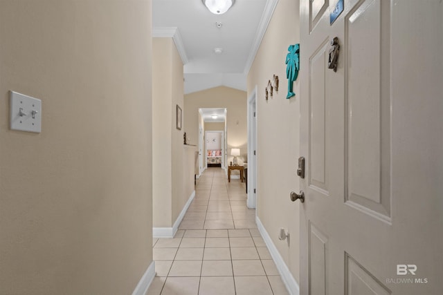 hallway with light tile patterned floors, crown molding, and vaulted ceiling