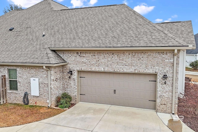 french country inspired facade featuring a garage, a shingled roof, and brick siding