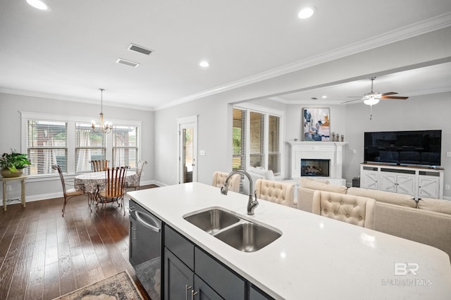 kitchen with light countertops, stainless steel dishwasher, dark wood-type flooring, open floor plan, and a sink