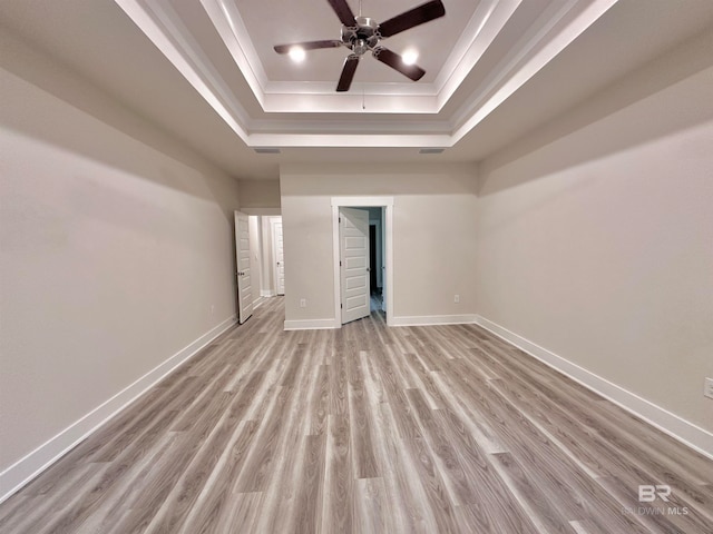 unfurnished bedroom with light hardwood / wood-style floors and a raised ceiling