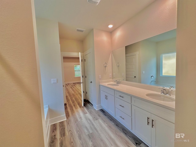 bathroom featuring a bath, wood-type flooring, and vanity