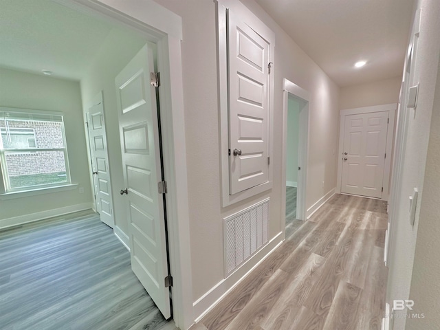 hallway with light hardwood / wood-style floors