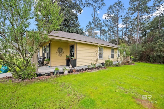 view of front facade with a front yard and a patio