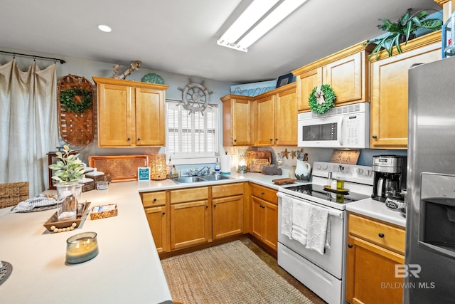 kitchen featuring a sink, white appliances, and light countertops