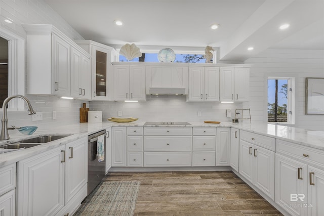kitchen featuring tasteful backsplash, white cabinets, black electric cooktop, stainless steel dishwasher, and a sink