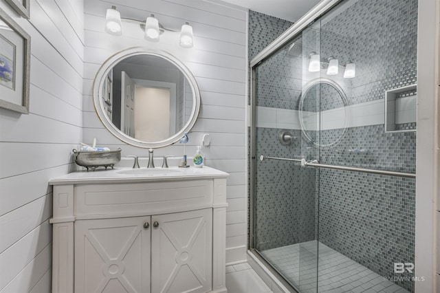 bathroom featuring a shower stall, wood walls, and vanity