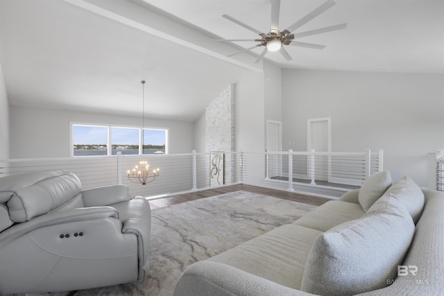 living area featuring ceiling fan with notable chandelier, vaulted ceiling with beams, and wood finished floors