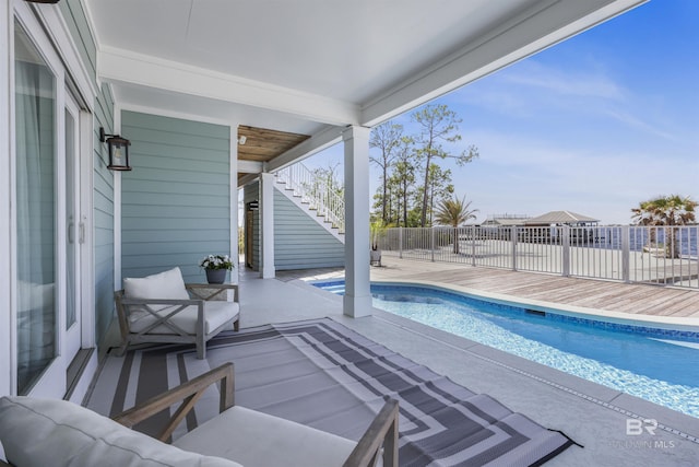 view of swimming pool featuring a patio area, a fenced in pool, fence, and stairway