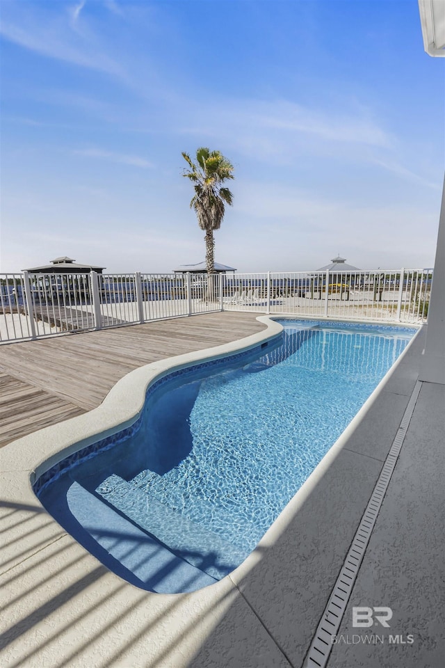 view of pool featuring a fenced in pool and a deck