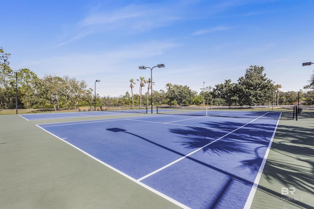 view of tennis court with fence and community basketball court