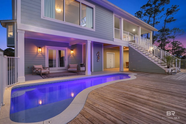 view of pool with a fenced in pool, stairway, and a wooden deck
