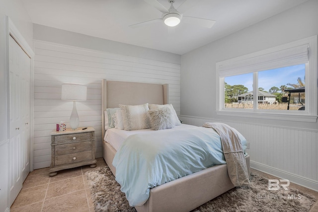 bedroom with wood walls and a ceiling fan