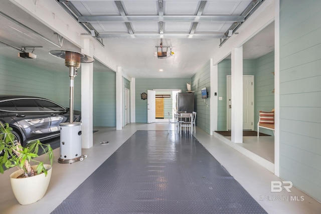 garage with wooden walls and a garage door opener