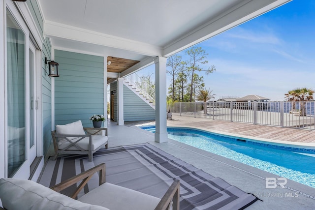 view of swimming pool featuring a patio area, fence, stairway, and a fenced in pool