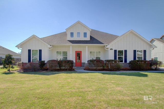 view of front facade with board and batten siding, a shingled roof, and a front yard