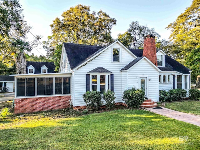 cape cod home with a sunroom and a front yard