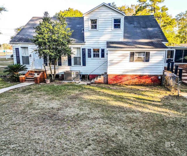 rear view of house featuring a yard and central AC unit