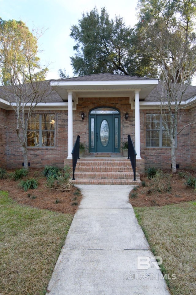 property entrance with a lawn and a porch