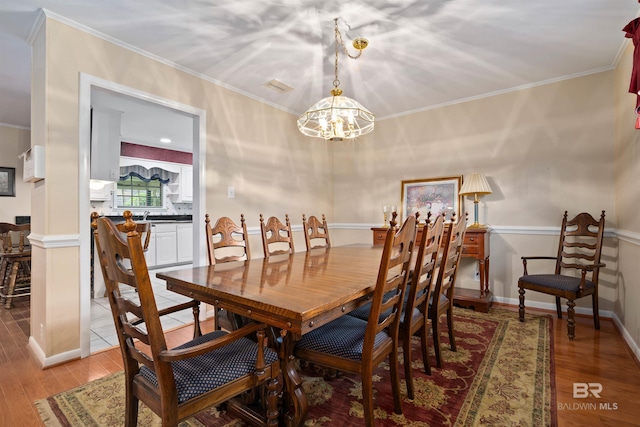 517 Simms Dr, Saraland, AL 36571 - dining area with a chandelier, light wood finished floors, and crown molding