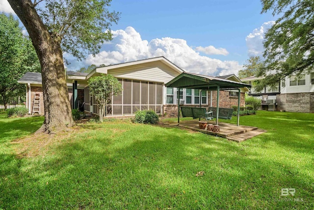 517 Simms Dr, Saraland, AL 36571 - rear view of property with brick siding, a sunroom, and a lawn