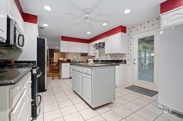 517 Simms Dr, Saraland, AL 36571 - kitchen with stainless steel appliances, ceiling fan, white cabinets, light tile patterned floors, and recessed lighting
