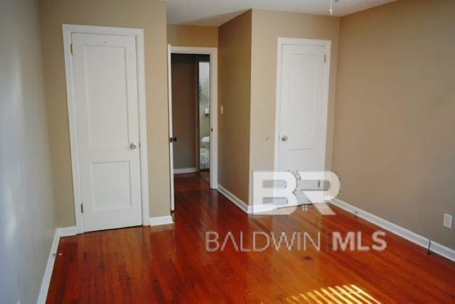 unfurnished bedroom with dark wood-type flooring