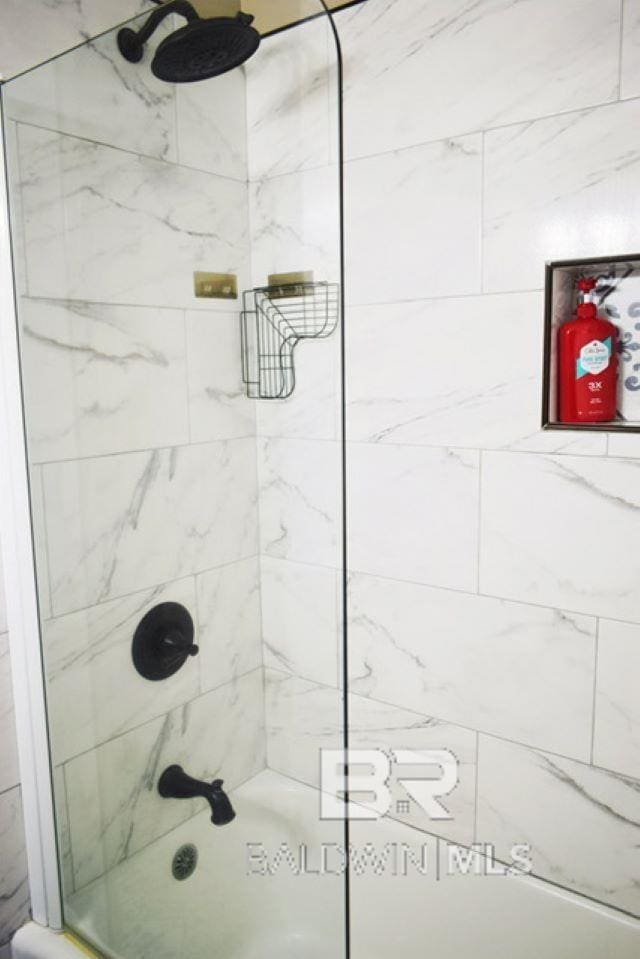 bathroom featuring tiled shower / bath