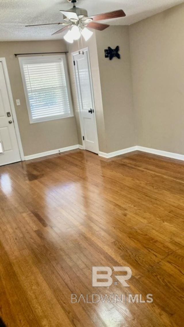 unfurnished room with hardwood / wood-style floors, a textured ceiling, and ceiling fan