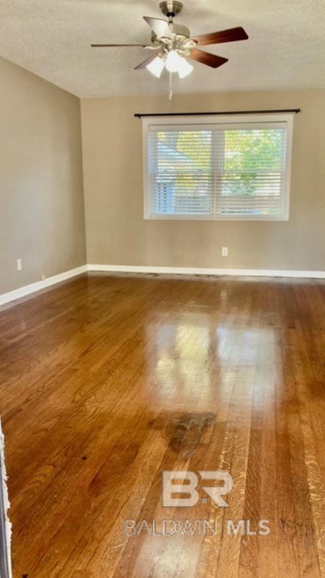 spare room featuring hardwood / wood-style flooring and a textured ceiling