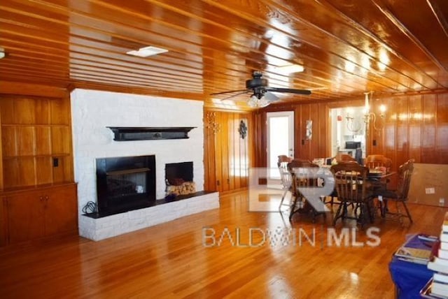 living room featuring hardwood / wood-style floors, ceiling fan, and wooden walls