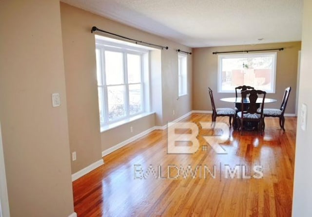 dining area with wood-type flooring and a textured ceiling