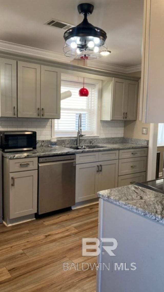 kitchen with ornamental molding, stainless steel appliances, sink, light hardwood / wood-style flooring, and gray cabinets