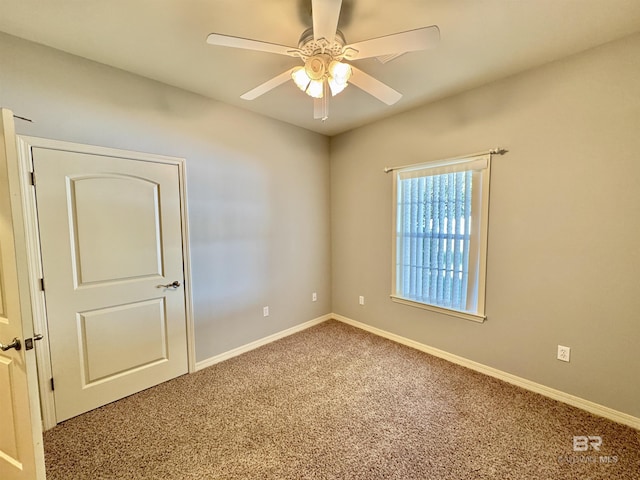 carpeted spare room featuring ceiling fan