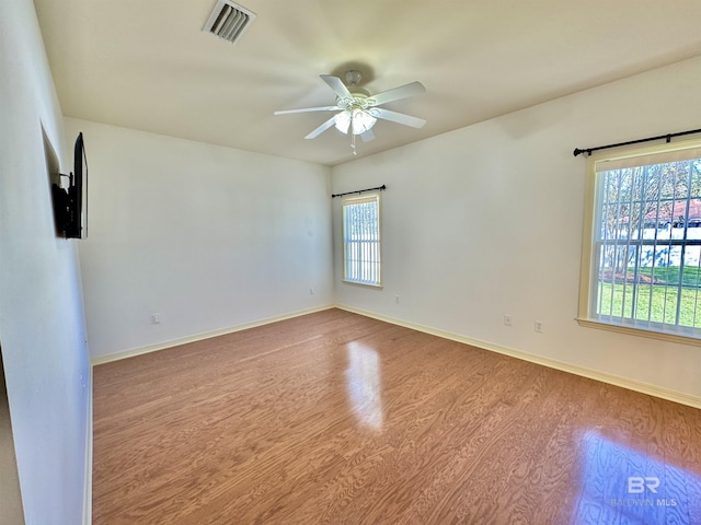 empty room with light wood-type flooring, plenty of natural light, and ceiling fan