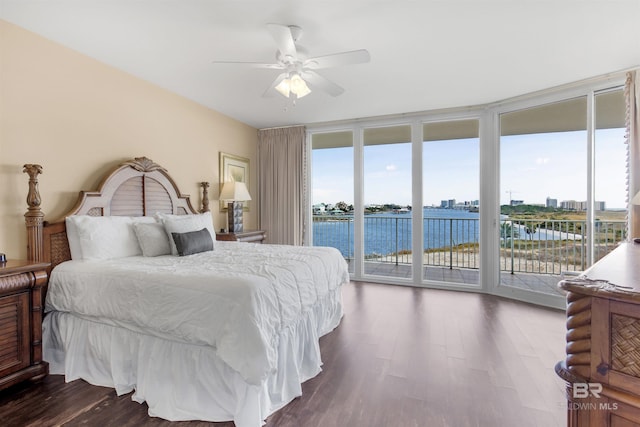 bedroom featuring access to exterior, ceiling fan, a water view, and dark hardwood / wood-style floors