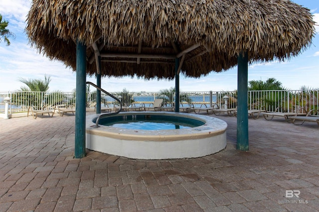 view of pool with a gazebo, a patio area, a water view, and a hot tub