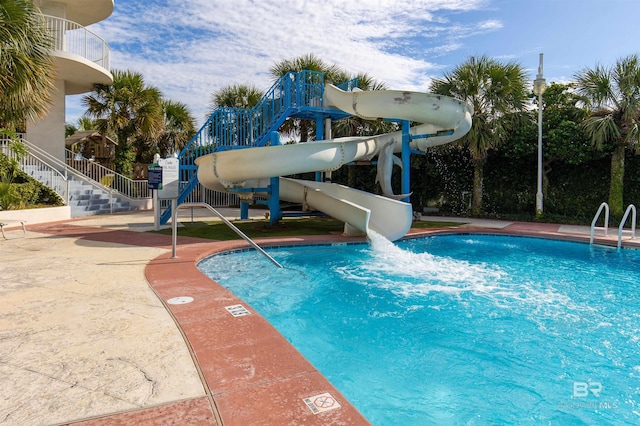 view of swimming pool with a water slide