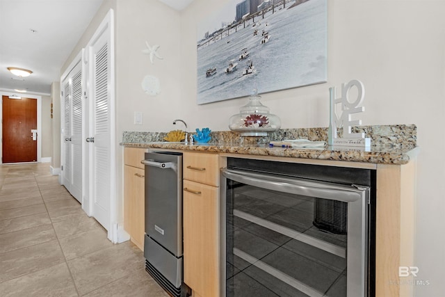 kitchen featuring sink, wine cooler, light stone counters, light brown cabinetry, and light tile patterned floors