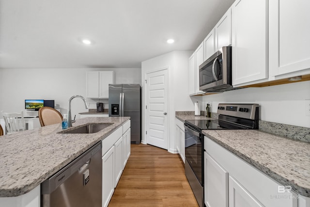 1149 Hayward Loop, Foley, AL 36535 - kitchen featuring appliances with stainless steel finishes, a sink, white cabinetry, light wood-style floors, and recessed lighting