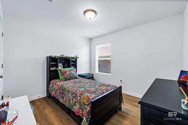 1149 Hayward Loop, Foley, AL 36535 - bedroom featuring wood finished floors, baseboards, and a textured ceiling
