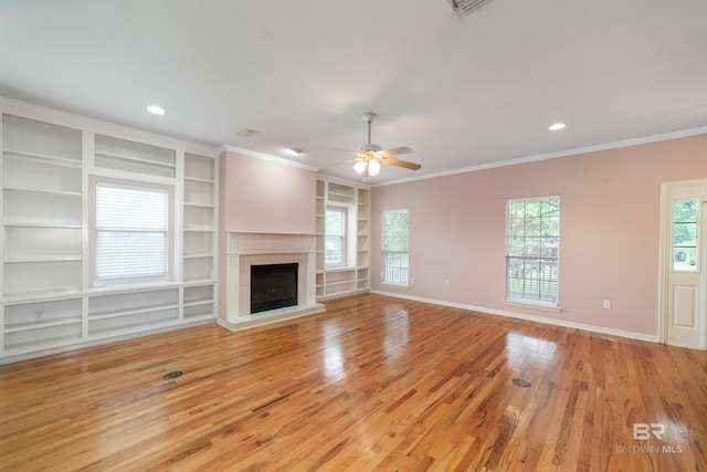 5039 W Cole Dr, Mobile, AL 36619 - unfurnished living room with built in features, light wood-style floors, baseboards, ceiling fan, and a tile fireplace